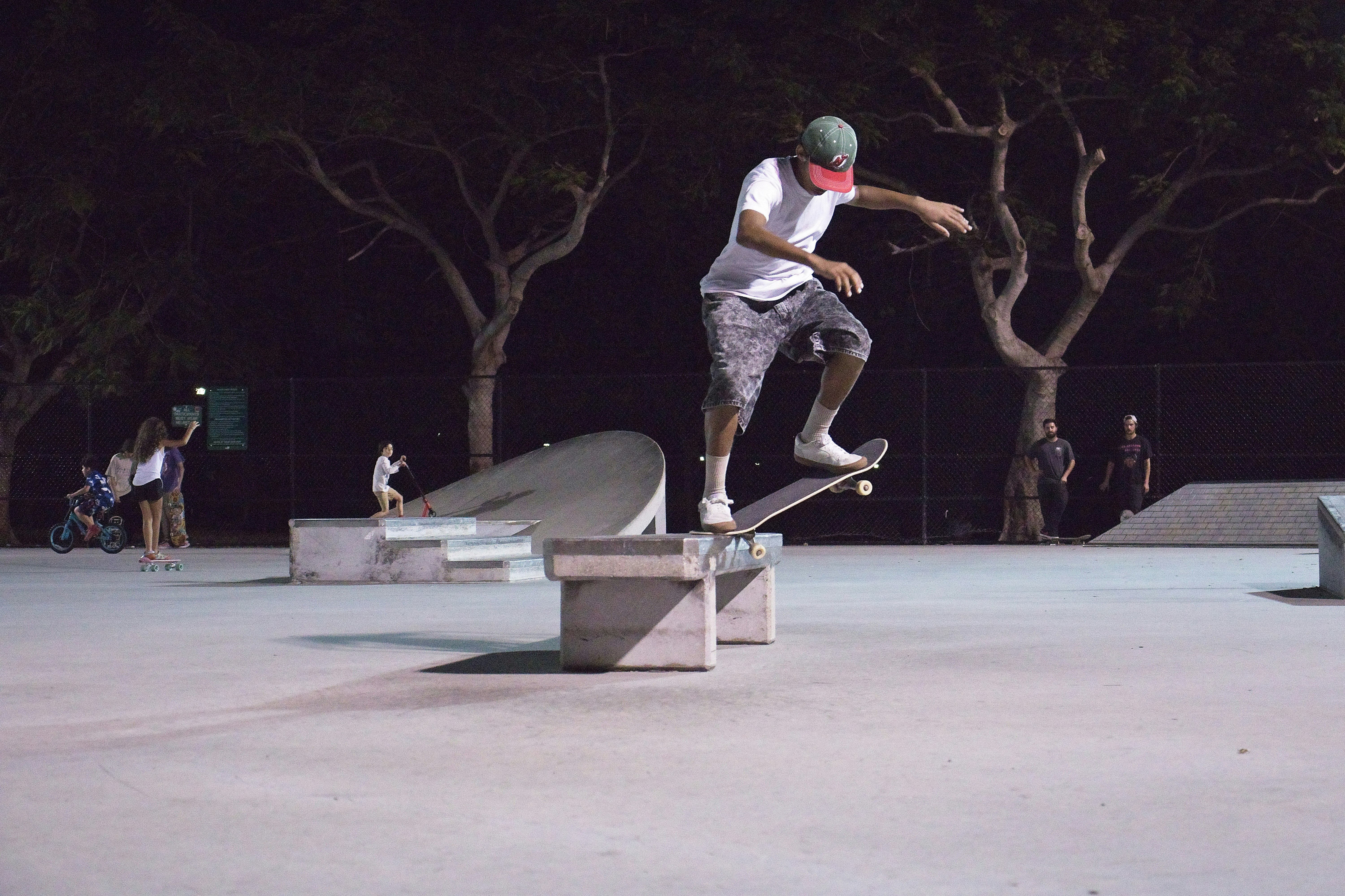 man in white t-shirt and gray pants playing skateboard during daytime